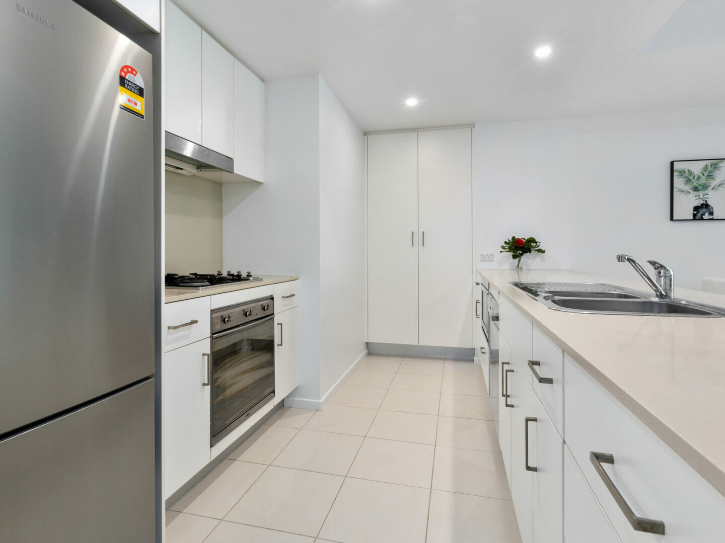 Kitchen with peninsula shaped layout, stainless steel fridge, wall oven, dishwasher, microwave and sink