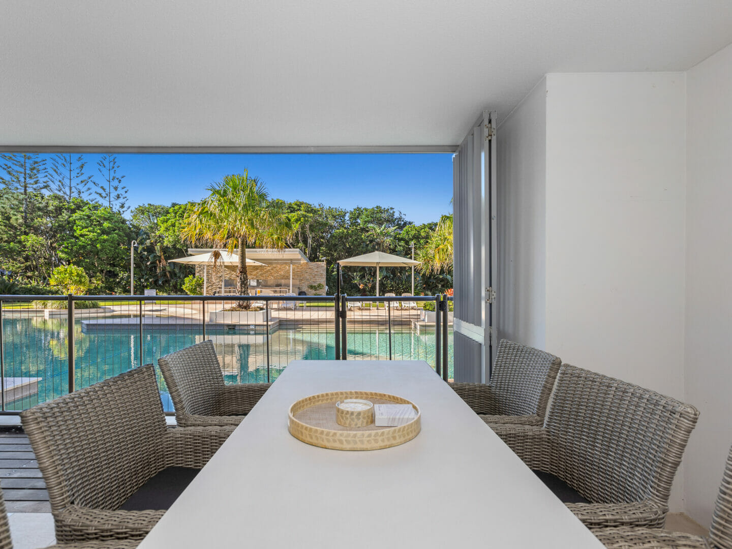 Pool deck area with outdoor dining table for six, overlooking pool